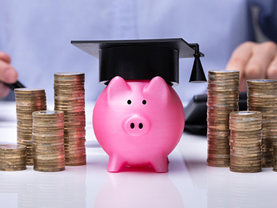 College savings and education planning concept with piggy bank, graduation cap, and stacked coins