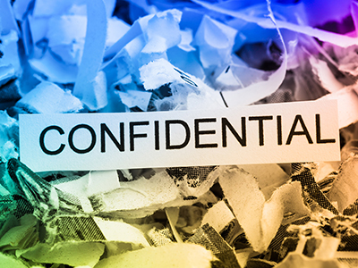 Confidential document disposal and data security concept with shredded papers and confidential label