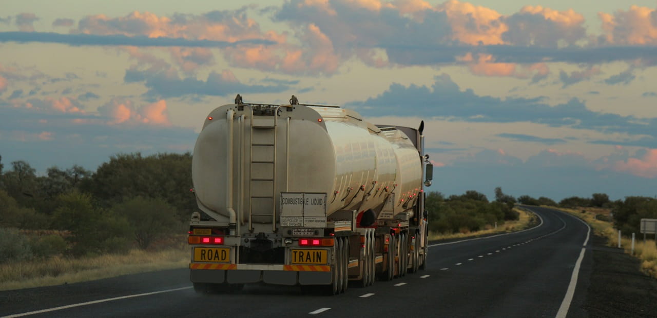 Fuel tanker on a highway, representing volatile gas prices affecting U.S. household costs.