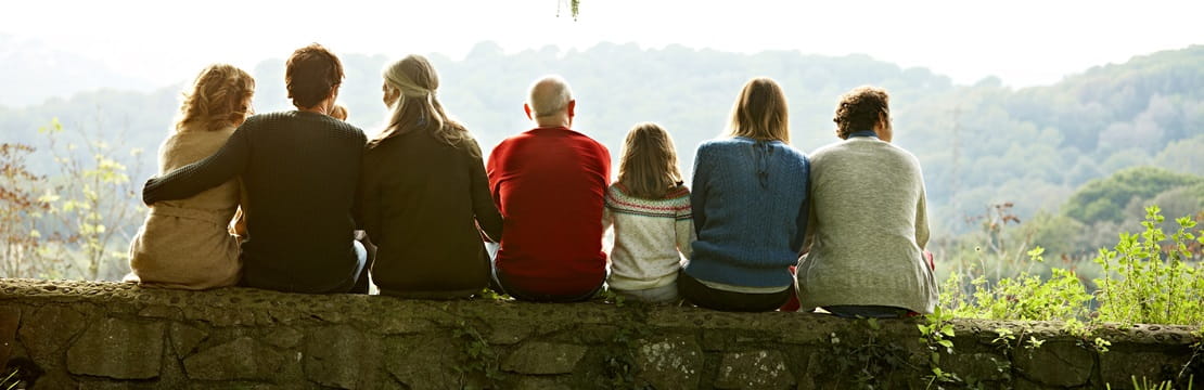 Multi-generation family relaxing on retaining wall