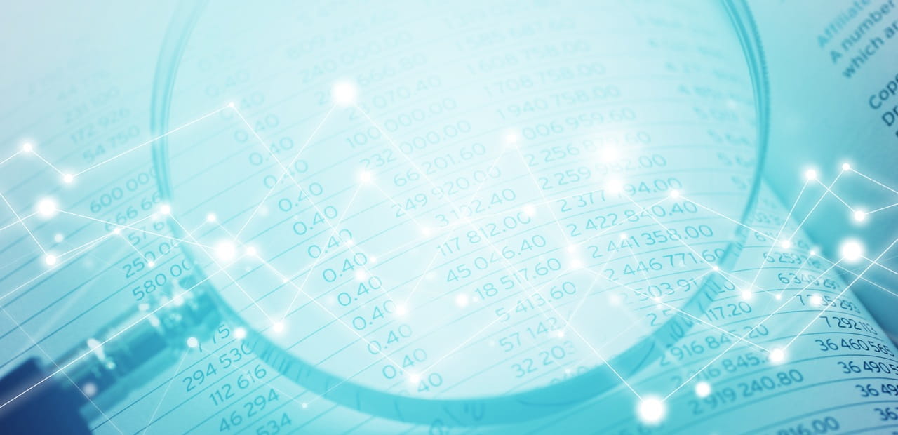 A magnifying glass highlighting rows of numerical data on a spreadsheet