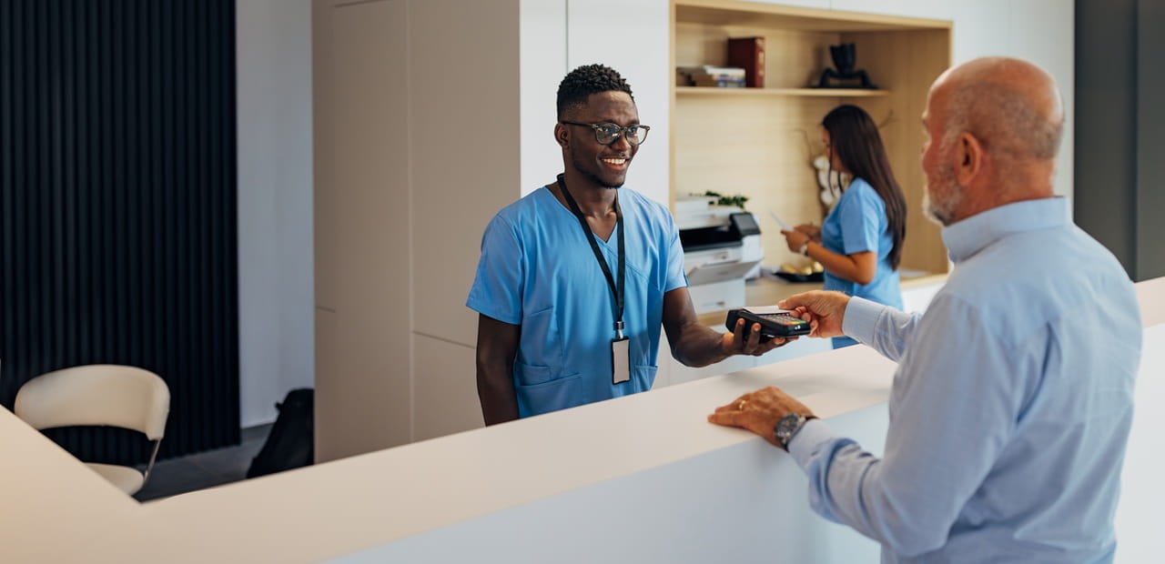 Person paying for a medical service, illustrating how a Health Savings Account can be used to invest for retirement and help cover healthcare costs that Medicare does not.