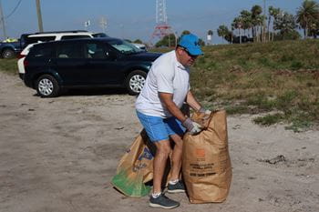 Feller picks up a full yard waste bag.