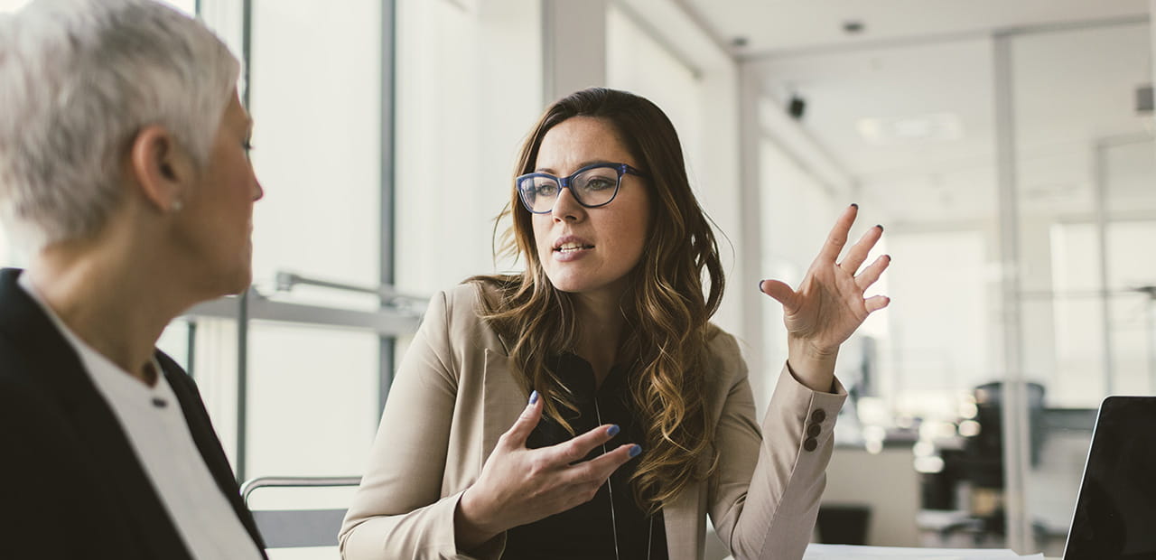 Businesswomen have meeting in the office. Mature woman and mid adult woman sitting and discussing