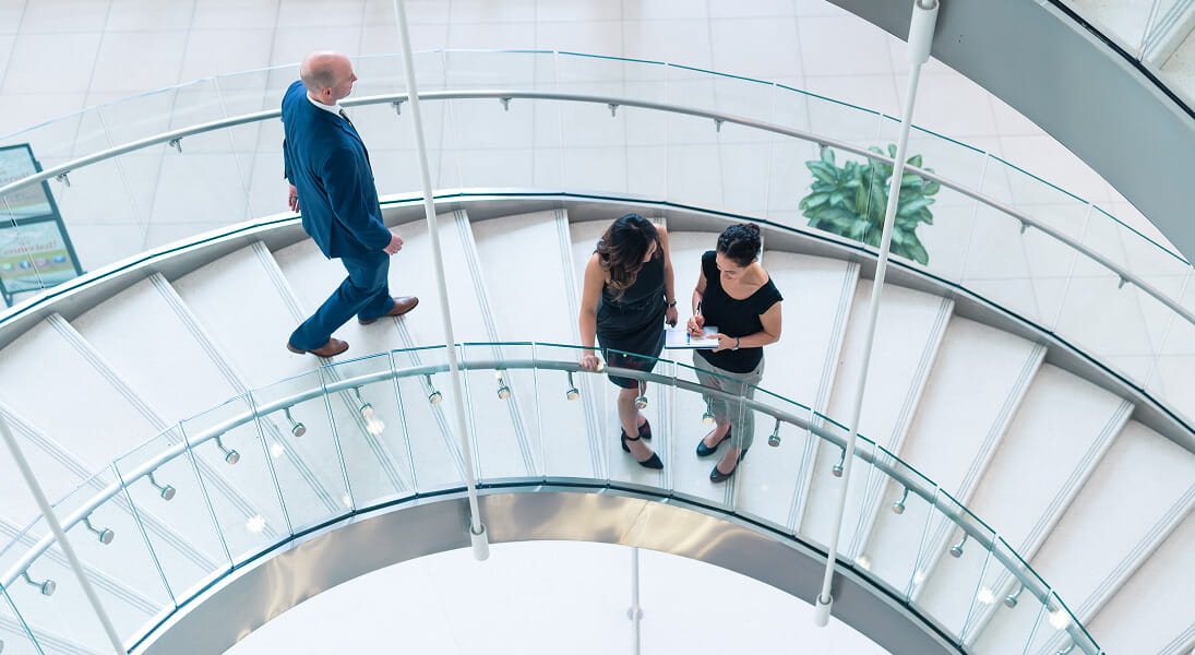 Associates walking down a spiral staircase