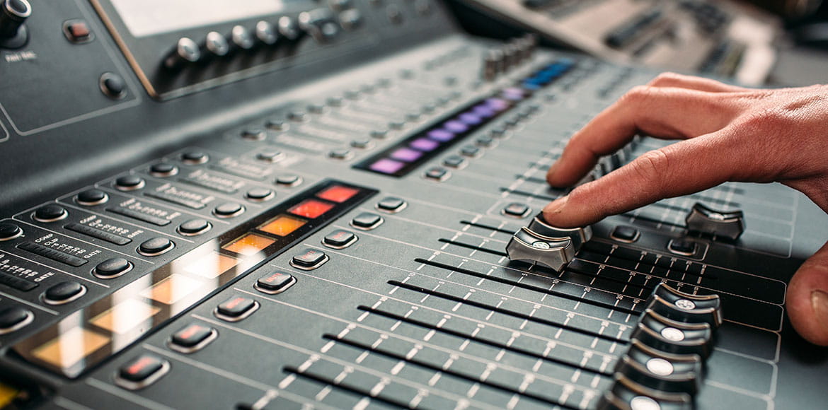 Person-moving-slider-on-professional-sound-mixing-desk